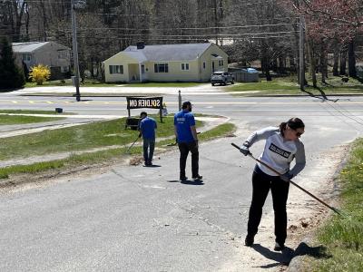 three people clean up a driveway at soldier on