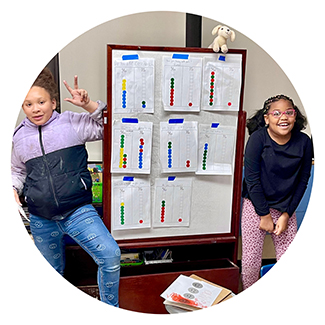 two girls in front of a white board