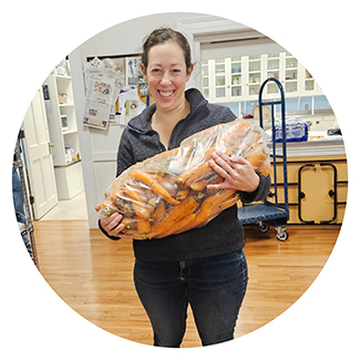 woman holding large bag of carrots