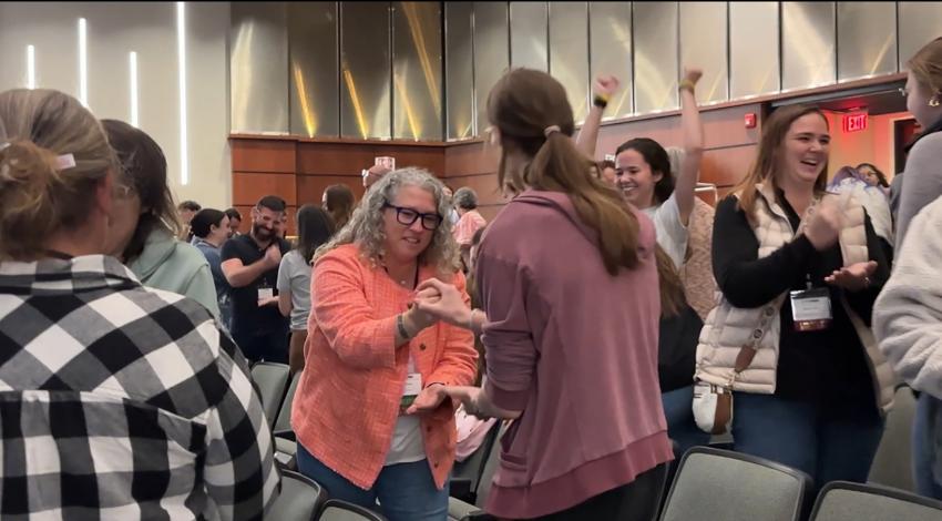 two women play rock, paper, scissors