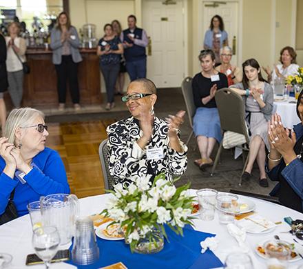 two women clapping at an event