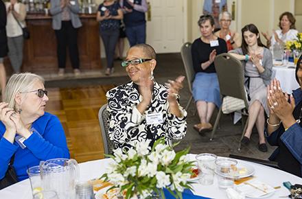 two women clapping at an event