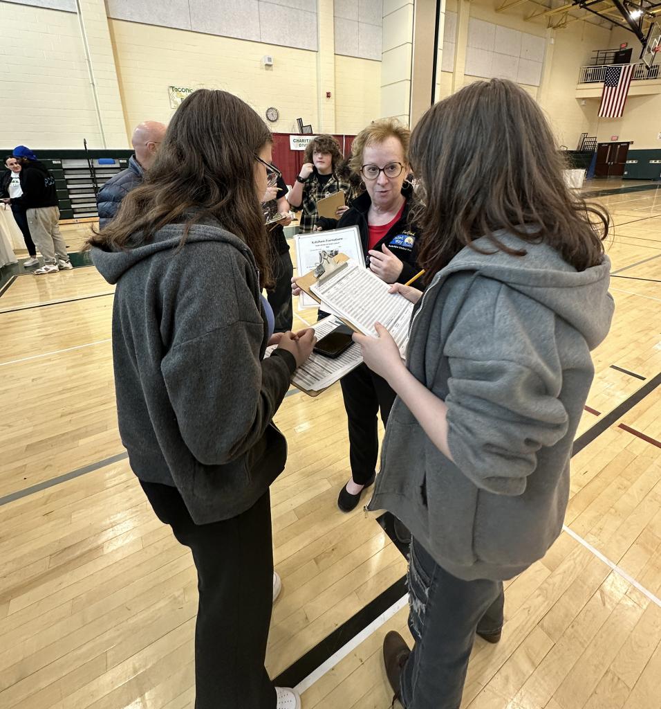 Pam Knisley, Community Engagement Manager, helps students pick out furniture