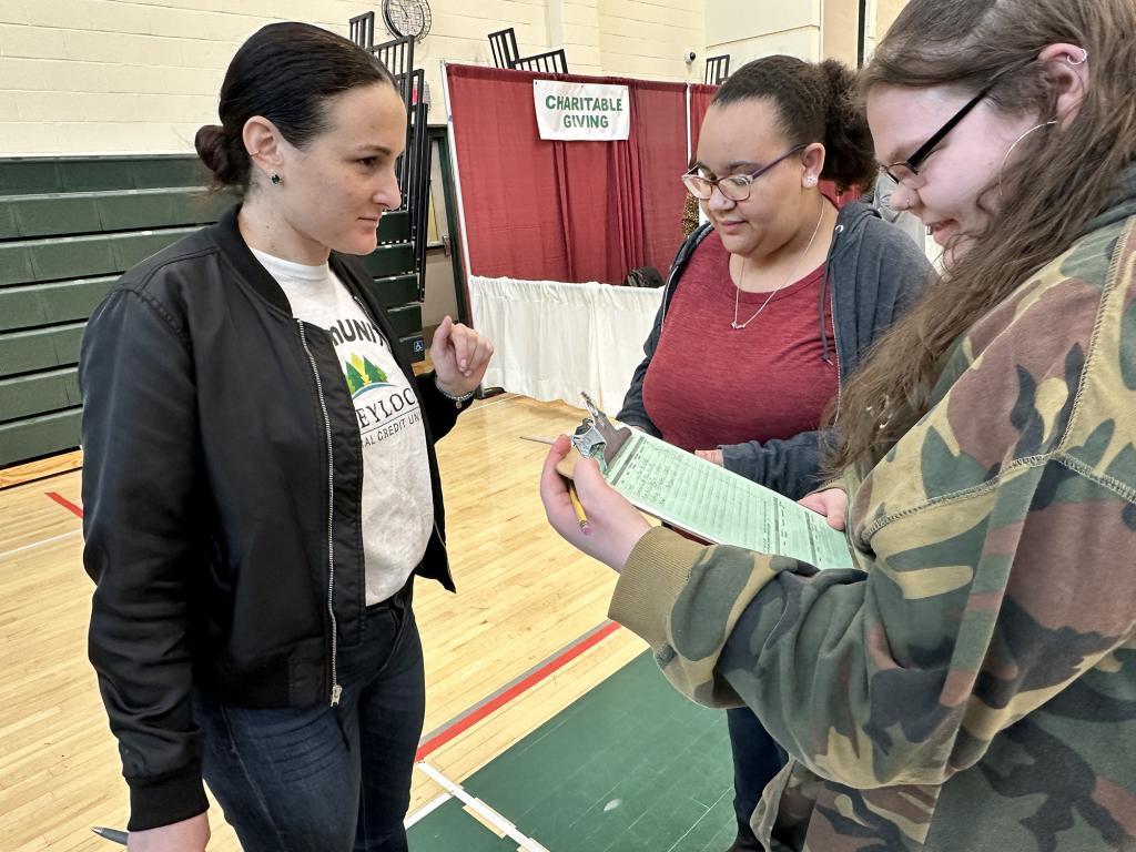 Volunteer Sophia Romeu from Greylock Federal Credit Union helps them decide on housing