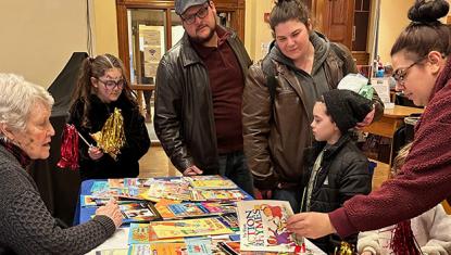 volunteer helps family picks out books